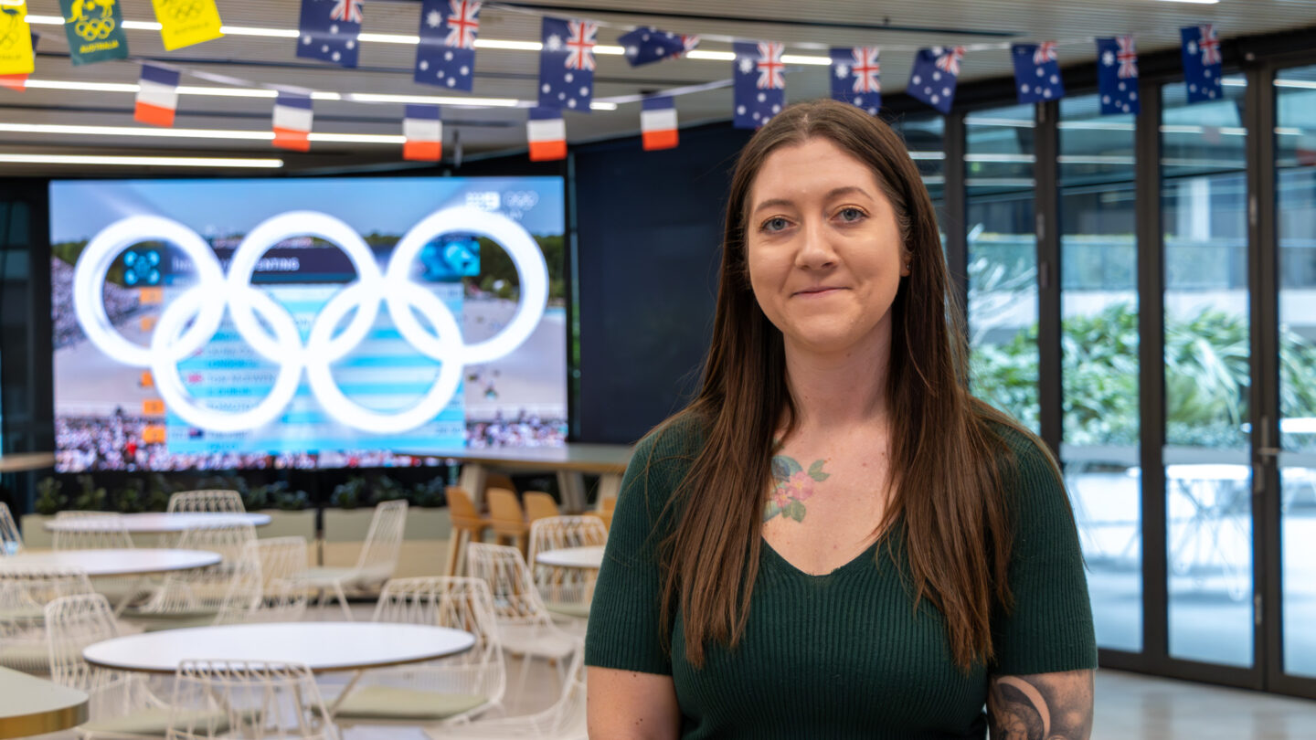 Carly Ballette in the cafeteria with Australia flags and Olympic rings