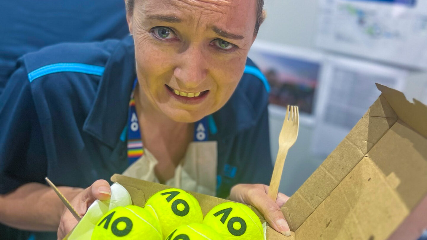 Sam Rutledge poses with a take away container full of tennis balls and a knife and fork as part of the team games exercise during the AO 