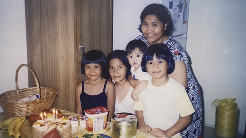 Georgia Serrano's family sharing a meal together, photo taken from Share Table the Nine Cultural Diversity Community cookbook